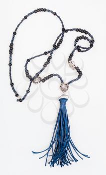 sautoir from black beads with blue leather brush on white background