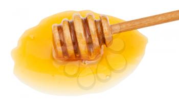 puddle of clear honey and wooden stick close up isolated on white background