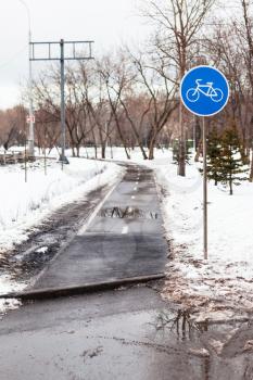 wet bicycle path in city in bad weather in early spring season