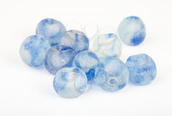 many beads from rough blue painted glass on white background