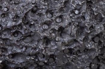 natural background - macro shooting of black porous pumice surface close up