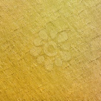 square textile background - yellow painted silk fabric with Jacquard weave pattern of threads close up