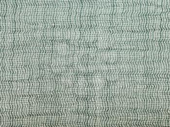 textile background - green transparent silk fabric with Crepon weave pattern of threads close up