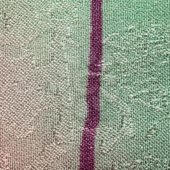 square textile background - green and magenta painted batik silk fabric with Jacquard weave pattern of threads close up