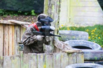 player in camouflage during playing paintball on open air field