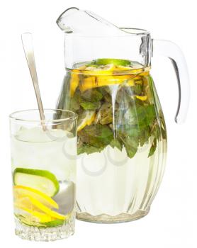 side view of glass pitcher and tumbler with natural lemonade drink from lemon, lime, mint isolated on white background