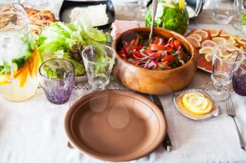 empty plate and appetizer from fresh tomatoes, cucumbers, red onion in wooden bowl on served table