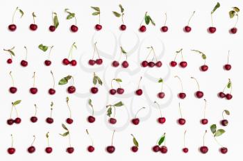 set from many ripe red cherries arranged on white background