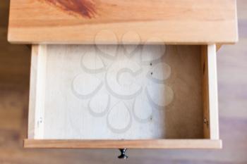 above view of empty open drawer of wooden nightstand