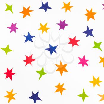 top view of various stars carved from colored paper on white square background