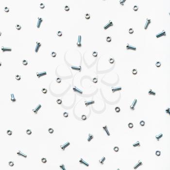 steel bolts and nuts on white square background