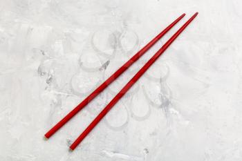 food concept - red wooden chopsticks on concrete board
