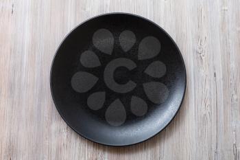 top view of one black plate on gray brown table