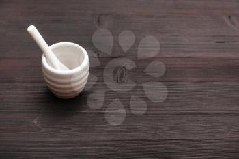 food concept - white ceramic cup for sake with spoon on dark brown wooden table