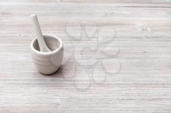 food concept - white ceramic cup for sake with spoon on gray brown wooden table