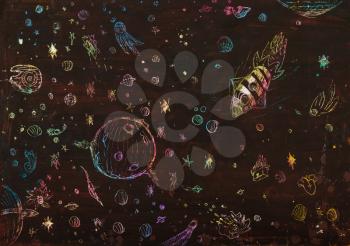 illustration painted by hand with wax and color chalks - space vehicles, rockets, planets and asteroids in the dark space