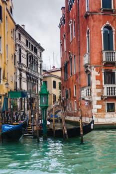 travel to Italy - mooring of gondolas near houses in Canal in Venice in rainy autumn day