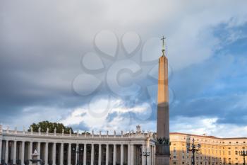 travel to Italy - obelisk with cross and Bernini's colonnade on Saint Peter's Square (Piazza San Pietro) in Vatican city in evening