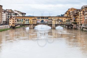 travel to Italy - muddy water of Arno river and view of Ponte Vecchio (Old Bridge) in Florence city in autumn