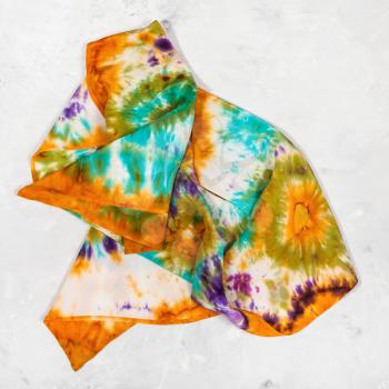 crumpled hand painted silk scarf on concrete plate