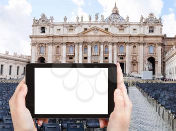 travel concept - tourist photographs St Peter square and Basilica in Vatican city on tablet with cut out screen with blank place for advertising in Italy