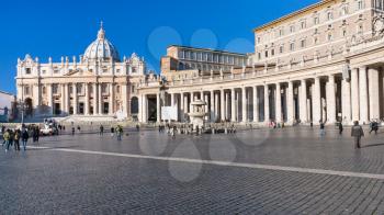 Travel to Italy - people on Piazza San Pietro (St Peter's Square) and view of St Peter Basilica in Vatican city in sunny winter day