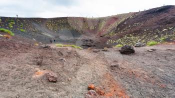 travel to Italy - people in old crater on Mount Etna in Sicily in summer day