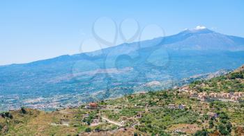 travel to Italy - panorama with villages on green hills and Etna volcano in Sicily
