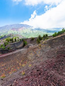 travel to Italy - tourists walk on path between old crater of Etna volcano in Sicily