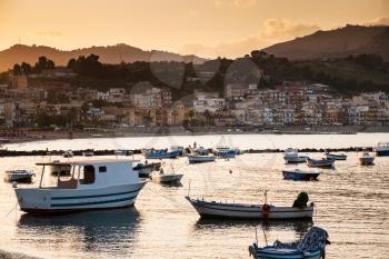 travel to Italy - boats in marina of Giardini Naxos town on sunset in Sicily