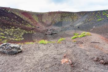 travel to Italy - tourists in old crater on Mount Etna in Sicily in summer day
