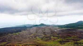 travel to Italy - low cloudy sky over lava fields on Mount Etna in Sicily in summer day