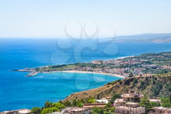 travel to Italy - view of Taormina city and giardini naxos resort on the coast of Ionian sea from Castelmola village in Sicily in summer day