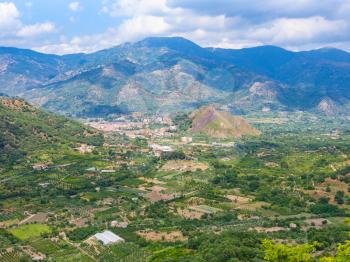 travel to Italy - above view of rural gardens and Francavilla di Sicilia town in mountain valley in Sicily