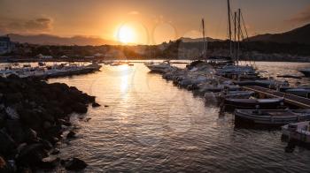 GIARDINI NAXOS, ITALY - JULY 6, 2011: boats mooring in Giardini Naxos town on sundown. Naxos was founded by Thucles the Chalcidian in 734 BC, and since 1970s it has become a seaside-resort