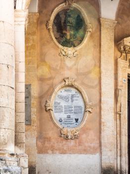 NOTO, ITALY - JULY 3, 2011: The inscription about including the city of Noto in the UNESCO World Heritage List as sample of sicilian baroque on wall of Palazzo Ducezio (Town Hall) in Noto city