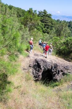 ETNA, ITALY - JULY 1, 2011 - tourists on overgrown slope over old crater of Etna volcano. Mount Etna is active volcano on the east coast of Sicily, the tallest active volcano in Europe