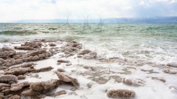 Travel to Middle East country Kingdom of Jordan - natural salt on beach of Dead Sea in winter