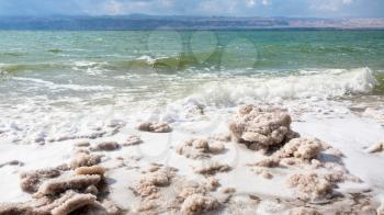 Travel to Middle East country Kingdom of Jordan - pieces of crystalline salt on surface of Dead Sea coast in winter
