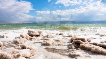 Travel to Middle East country Kingdom of Jordan - pieces of crystalline salt on surface of Dead Sea coastline in winter