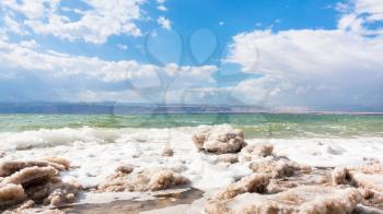 Travel to Middle East country Kingdom of Jordan - pieces of crystalline salt on surface of Dead Sea waterfront in winter