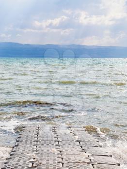 Travel to Middle East country Kingdom of Jordan - pontoon pier on coast of Dead Sea in winter