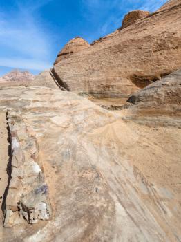 Travel to Middle East country Kingdom of Jordan - rocks with water collecting channel in Wadi Rum desert in winter