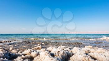 Travel to Middle East country Kingdom of Jordan - natural salt close up on coast of Dead Sea in sunny winter day