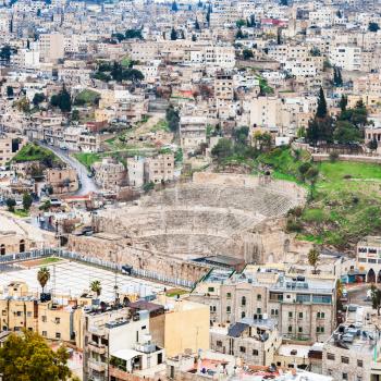 AMMAN, JORDAN - FEBRUARY 18, 2012: view of ancient Roman theater in Amman city from citadel in winter. The Amphitheatre was built the Roman period when the city was known as Philadelphia