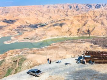 DHIBAN, JORDAN - FEBRUARY 20, 2012: tourists at viewpoint over Al Mujib dam on Wadi Mujib river on King's highway in winter. King's Road was trade route on ancient Near East from Egypt to Aqaba