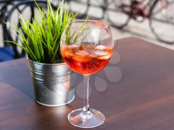 travel to Italy - glass of Spritz cocktail with ice on table in outdoor cafe in Padua city in spring