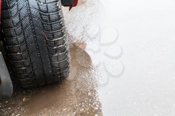 driving car in rain - view of vehicle tire on wet road