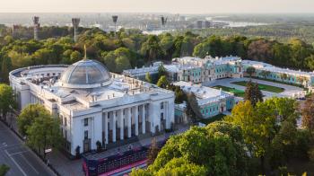 KIEV, UKRAINE - MAY 6, 2017: Verkhovna Rada building (parliament house) on hrushevsky street and Mariyinsky palace in Mariinsky park and Dnieper River on horizon in spring twilight