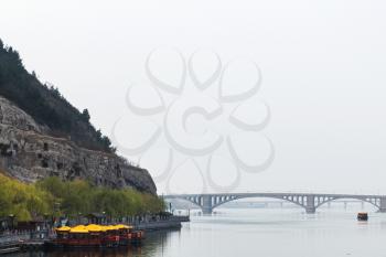 travel to China - view of bridge on Yi river and West Hill of Chinese Buddhist monument Longmen Grottoes (Dragon's Gate Grottoes, Longmen Caves) in spring season